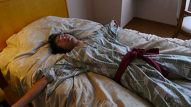 ホテルのベッドで眠る筆者