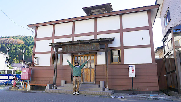 川渡温泉浴場の入り口でポーズをとる筆者