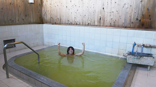 川渡温泉の湯船につかってガッツポーズする筆者