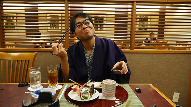 美味しい料理を食べて幸せそうに微笑むライター地主恵亮