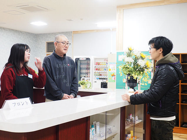 出町温泉のフロントで話を伺う風呂デューサー毎川直也