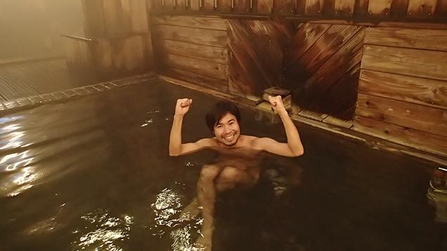 湯船に浸かってガッツポーズをする筆者