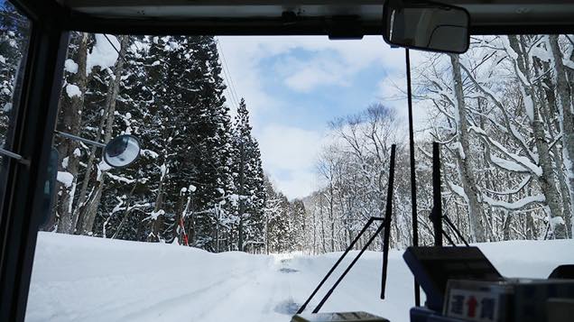 雪が積もった山道を進むバス