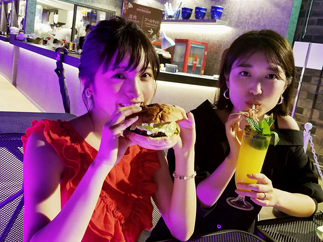 ハンバーガーをほおばる女性2人