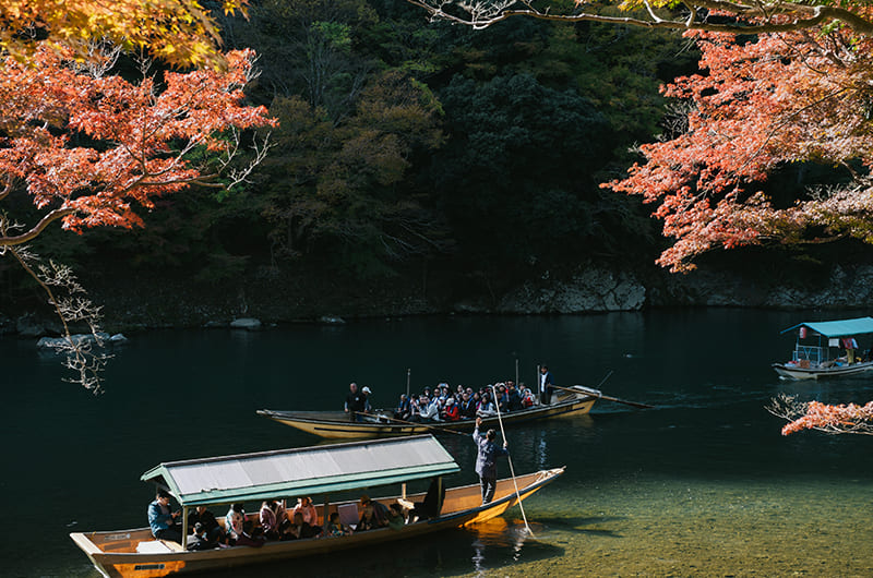 渡月橋から見える屋形船と紅葉