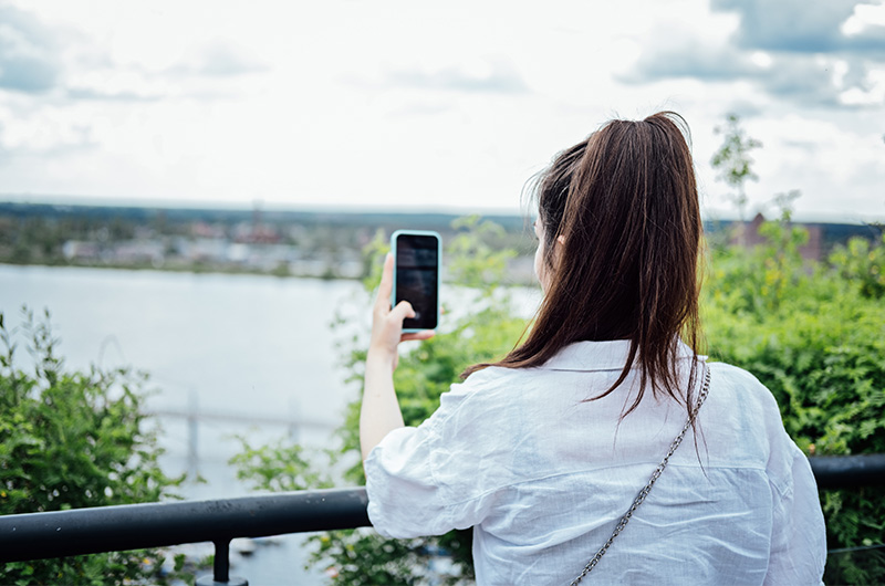 旅先の景色をスマートフォンで撮影するイメージ