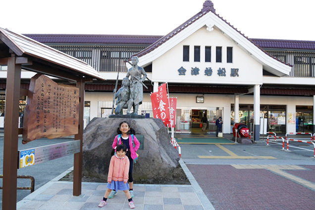 白虎隊士の像の前でポーズを取る姉妹