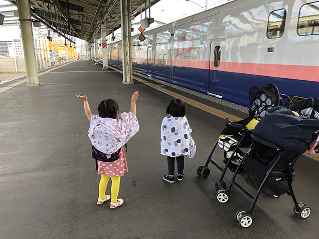 新幹線に手を振る子どもたち