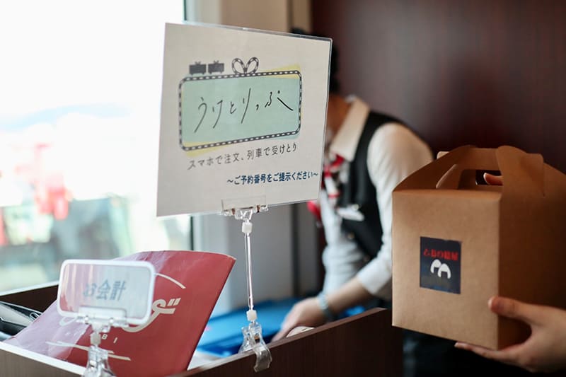 1号車の売店コーナーでお弁当を受け取る