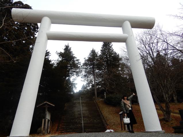 初代会津藩主保科正之が祀られる土津神社の白い鳥居前に立つ日笠麗奈